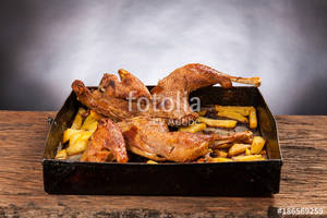 black background porn - Roast cut chicken with potatoes on a wooden table. Black background. Porn  food