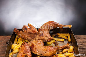 black background porn - Roast chicken with potatoes on a wooden table. Black background. Porn food