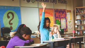 her student classroom - Girl raising hand in classroom