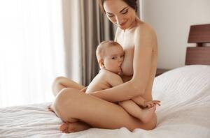 Lactating Mother - Free Photo | Young attractive nude mom breastfeeding hugging her newborn  baby smiling sitting on bed at home.