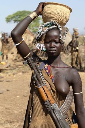 big breast african tribe - Mursi tribe in Ethiopia, a Mursi woman with a Kalashnikov, Lower Omo Valley,