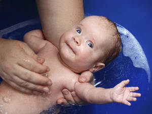 Baby Boy Mom Sex - Mum giving her newborn baby a bath in a baby bath tub