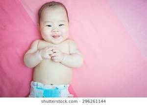 naked asian babies - Asian baby girl wear diaper smile and tongue out. She lay on pink bed and