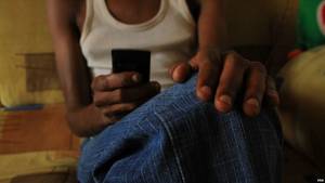 Mombasa Porn - Seventeen year-old sex worker checks email on his mobile phone, Mombasa,  Kenya