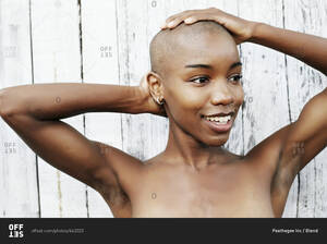 bald black lady naked - Close up of naked black woman rubbing bald head stock photo - OFFSET