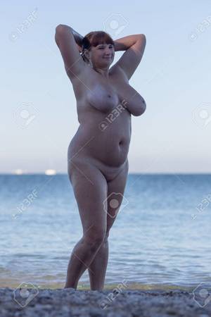 fat middle aged nudes - Overweight middle aged woman at the sea. Alone naked woman posing with arms  raised in