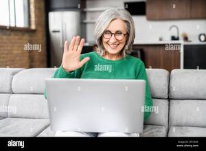 mature web cam videos - Modern mature woman in touch with a family, friends or colleagues via video  connect. Senior female