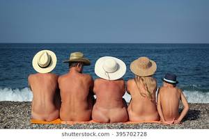 natural nude beach in buttox - Naked family in hats sitting on the beach